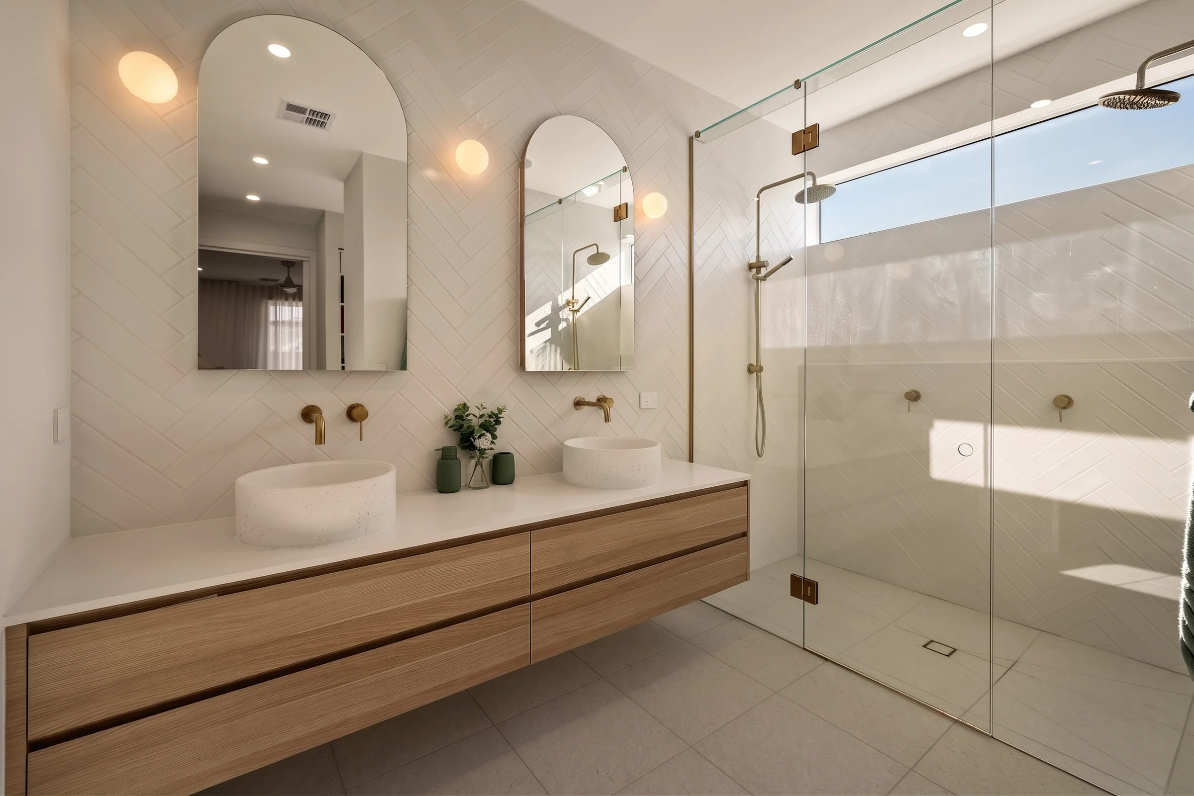 Ensuite with a double vanity, arched mirrors and a walk-in shower