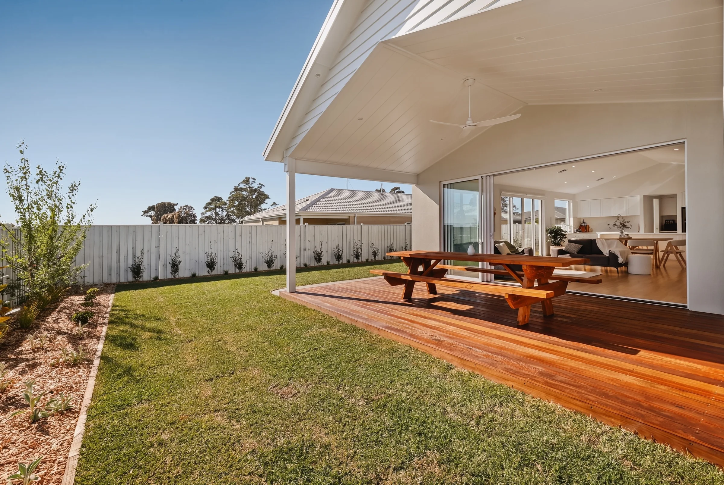 Covered timber deck opening onto the lawn